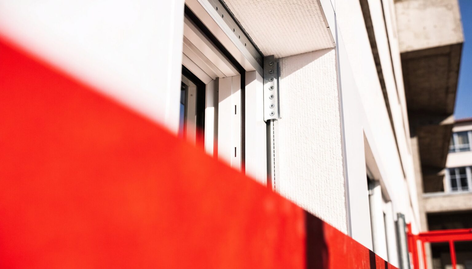 Fenster wird mit Metall-Montagekonsolen in der Dämmebene einer Fassade befestigt – sichere Vorwandmontage